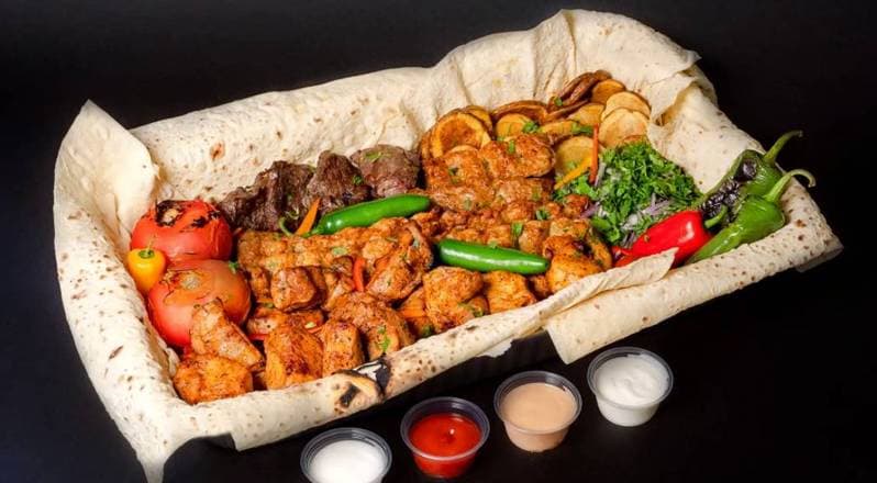 Family combo spread with carved chicken and beef shawarma, rice, fries, pita, and toum tubs, Patar Shawarma Glendale