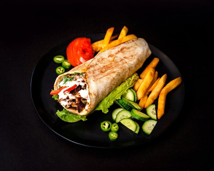 Mixed chicken and beef shawarma wrap cut in half showing both meats, pickles, and garlic sauce, Patar Shawarma Glendale