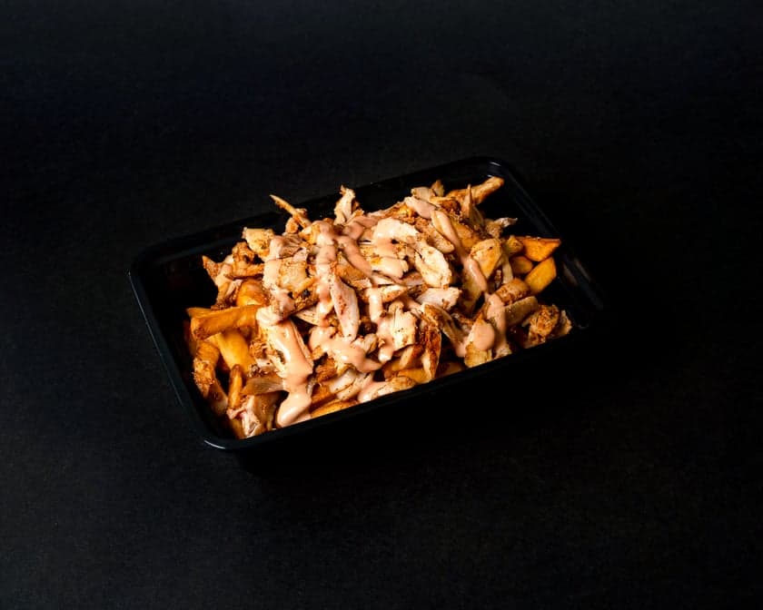 Crispy fries loaded with carved shawarma, garlic sauce, pickled turnips, and onion in a bowl at Patar Shawarma Glendale