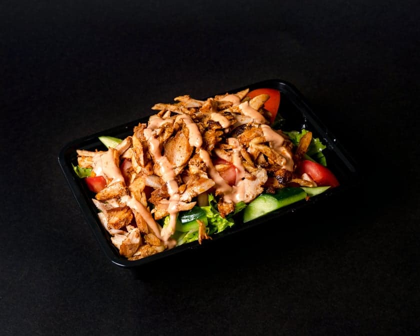 Carved shawarma over crisp salad with garlic sauce, pickles, and fresh jalapeño in a bowl at Patar Shawarma Glendale
