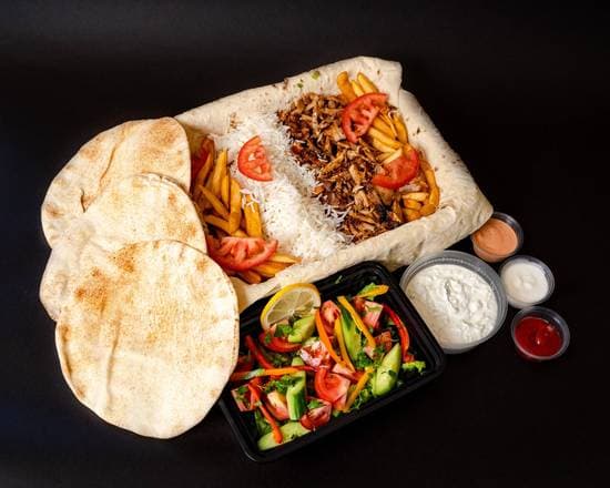 Shawarma plate with carved meat over seasoned rice, salad, pickled turnips, pita, and toum at Patar Shawarma Glendale
